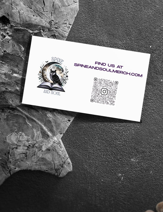 White business card with logo and QR code on a textured black surface